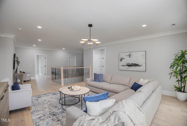 living room featuring an inviting chandelier, ornamental molding, and light hardwood / wood-style floors