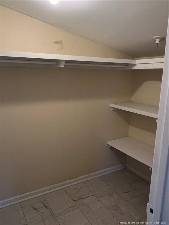 walk in closet featuring lofted ceiling