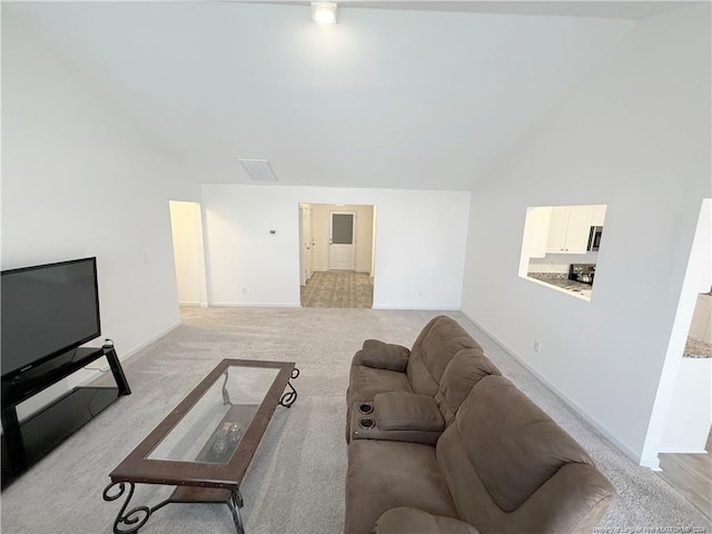 carpeted living room featuring high vaulted ceiling