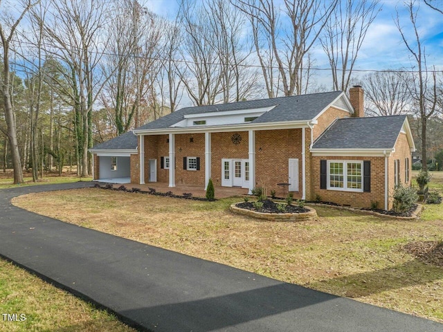 view of front of property with french doors and a front lawn