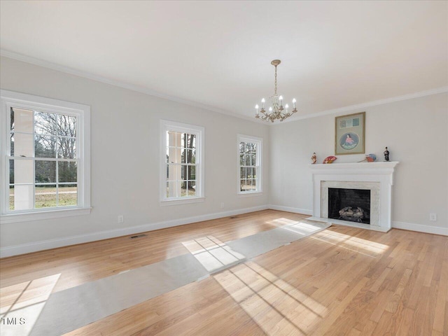 unfurnished living room with light hardwood / wood-style floors, ornamental molding, and a chandelier