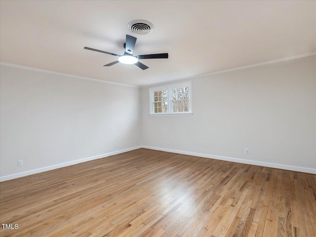 spare room with light hardwood / wood-style floors and crown molding