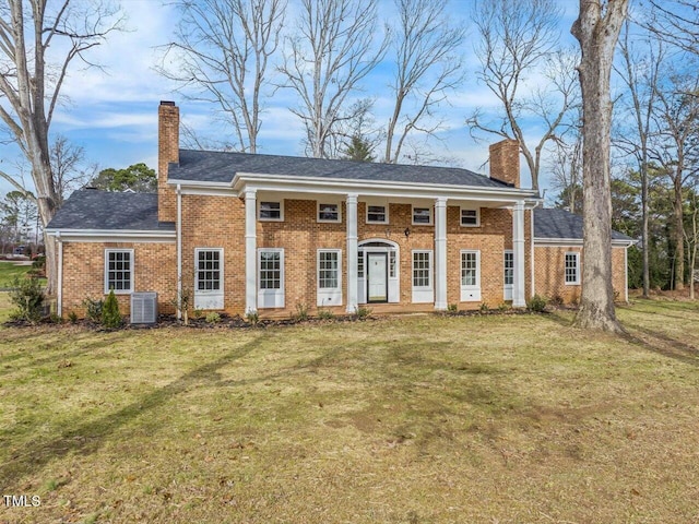 view of front of home with a front lawn and central AC unit