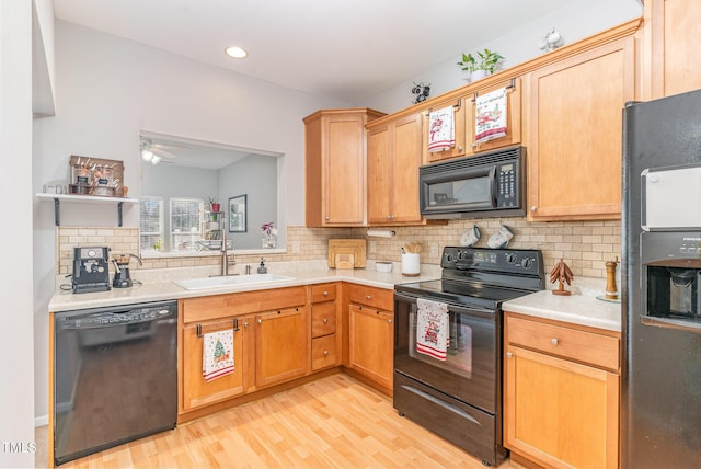 kitchen featuring ceiling fan, sink, backsplash, black appliances, and light wood-type flooring