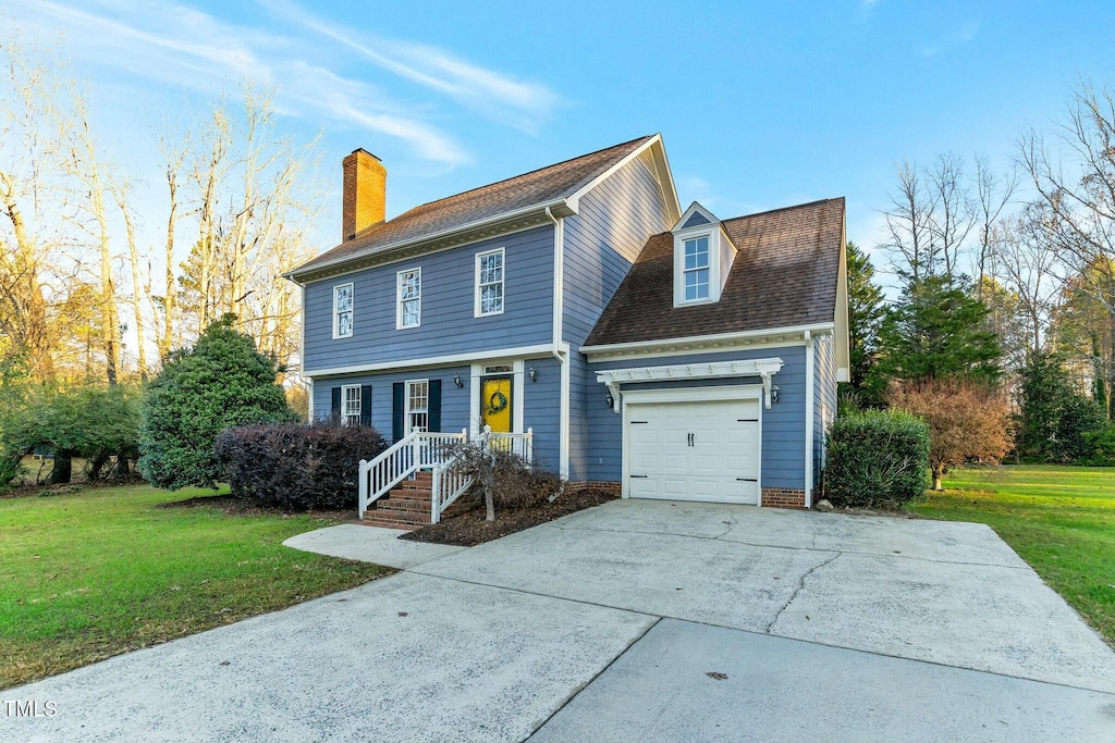 view of front of home with a front yard and a garage