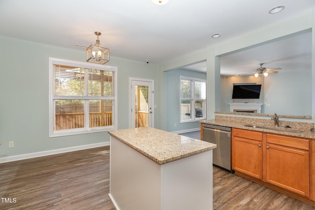 kitchen featuring sink, a center island, stainless steel dishwasher, dark hardwood / wood-style flooring, and light stone countertops