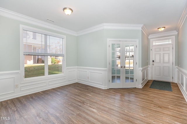 entrance foyer with hardwood / wood-style floors, ornamental molding, and french doors