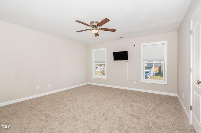 carpeted spare room with a wealth of natural light and ceiling fan