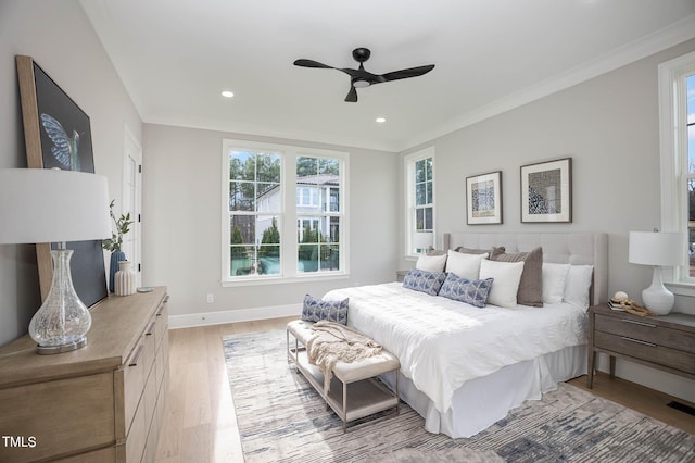 bedroom featuring ceiling fan, light wood-type flooring, and crown molding