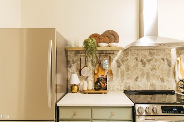 kitchen featuring appliances with stainless steel finishes, green cabinetry, and wall chimney exhaust hood