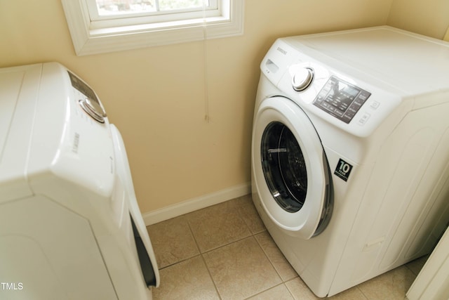 washroom featuring washer / clothes dryer and light tile patterned floors