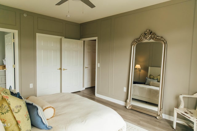 bedroom with connected bathroom, hardwood / wood-style flooring, and ceiling fan