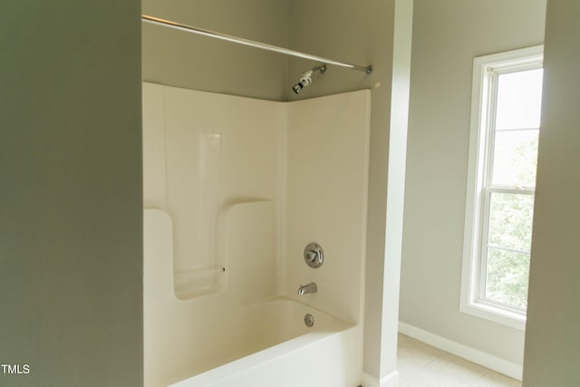 bathroom with tile patterned flooring, plenty of natural light, and washtub / shower combination