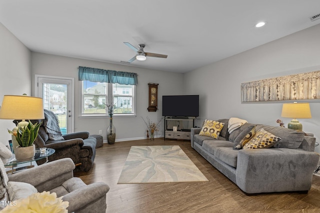 living room with ceiling fan and dark wood-type flooring