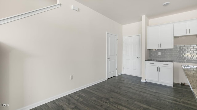 kitchen with tasteful backsplash, white cabinetry, and dark hardwood / wood-style flooring