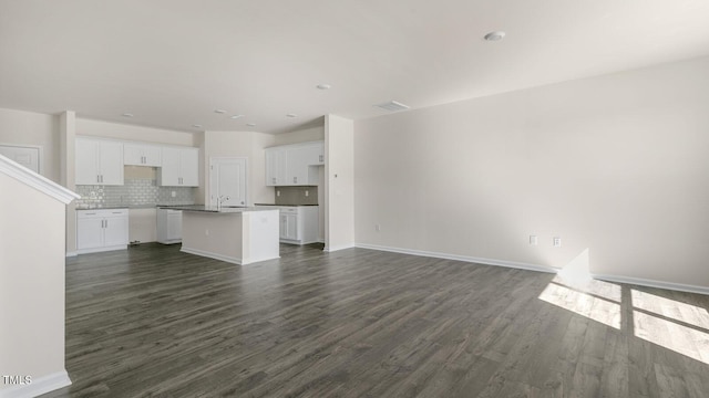 unfurnished living room featuring dark hardwood / wood-style floors and sink