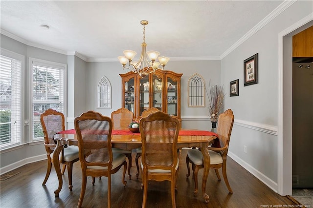 dining room with dark hardwood / wood-style floors, crown molding, and a notable chandelier