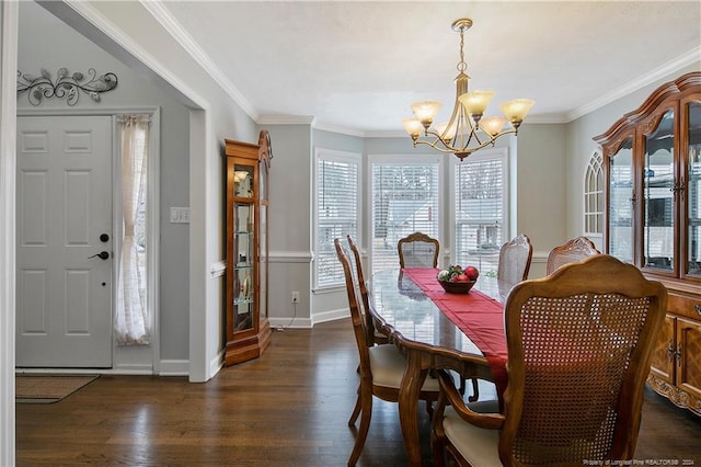 dining room with dark hardwood / wood-style flooring, ornamental molding, and an inviting chandelier