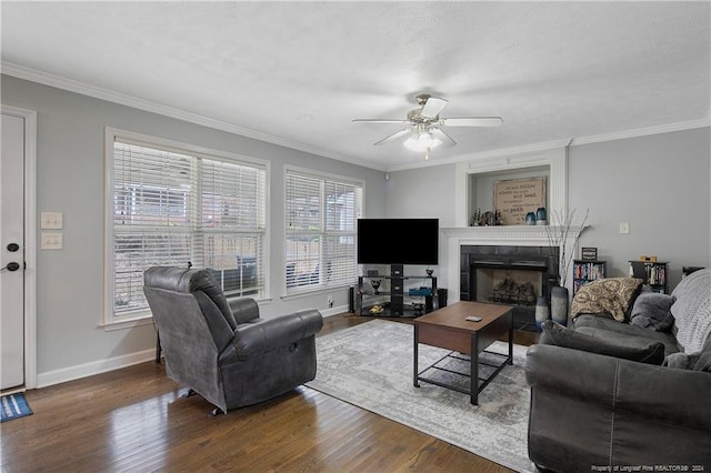 living room with a fireplace, dark hardwood / wood-style floors, ceiling fan, and crown molding