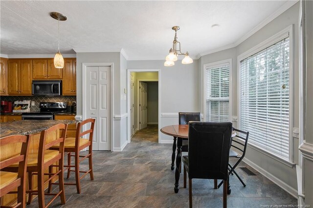 dining space featuring crown molding and an inviting chandelier