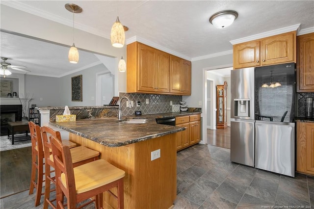 kitchen with kitchen peninsula, stainless steel refrigerator with ice dispenser, tasteful backsplash, ornamental molding, and decorative light fixtures