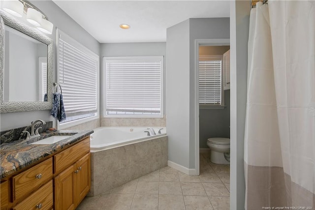 bathroom with tiled tub, tile patterned flooring, vanity, and toilet