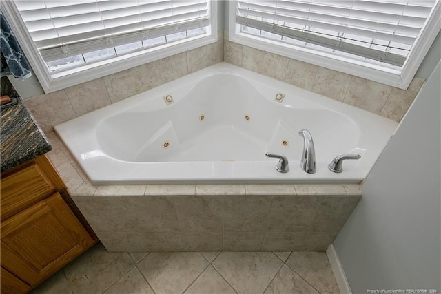 bathroom with a relaxing tiled tub and tile patterned floors