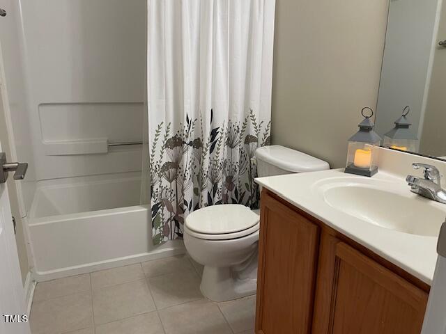 full bathroom featuring tile patterned flooring, vanity, toilet, and shower / bath combo with shower curtain