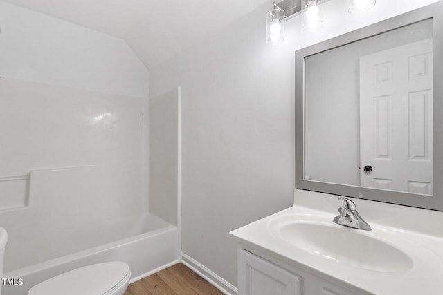 full bathroom with bathtub / shower combination, vanity, vaulted ceiling, hardwood / wood-style flooring, and toilet