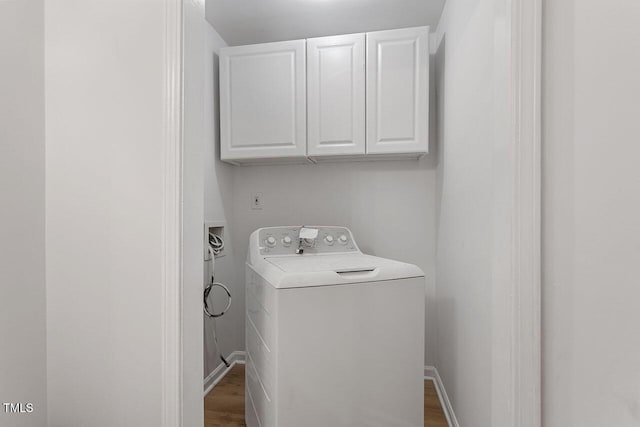 clothes washing area featuring cabinets, dark hardwood / wood-style flooring, and washer / clothes dryer