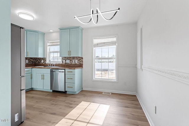 kitchen featuring blue cabinetry, a healthy amount of sunlight, and stainless steel appliances