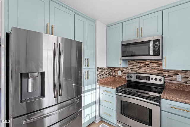 kitchen with appliances with stainless steel finishes, backsplash, and blue cabinets