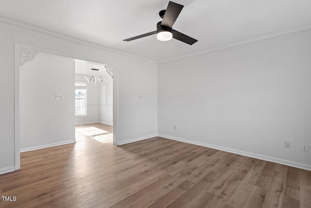 spare room featuring ceiling fan with notable chandelier, crown molding, and light hardwood / wood-style flooring