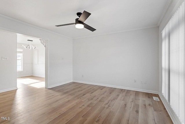 unfurnished room featuring ceiling fan with notable chandelier, light hardwood / wood-style flooring, and crown molding