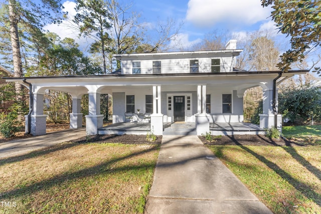 view of front of house with covered porch and a front yard