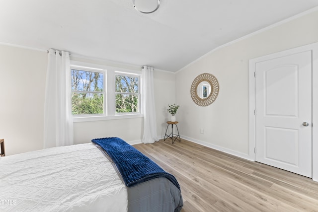 bedroom featuring ornamental molding and light hardwood / wood-style flooring