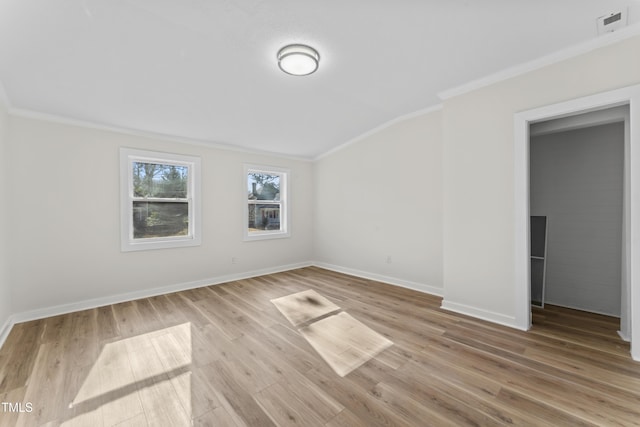 spare room featuring light hardwood / wood-style floors and crown molding