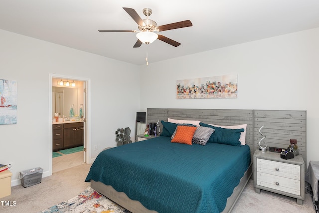 carpeted bedroom featuring ceiling fan and ensuite bath