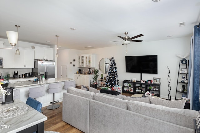 living room featuring ceiling fan and light hardwood / wood-style floors