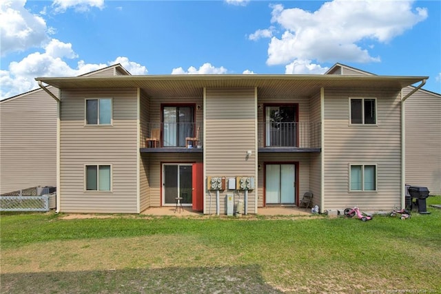 back of house featuring a yard and a balcony