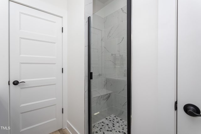 bathroom with a shower with door