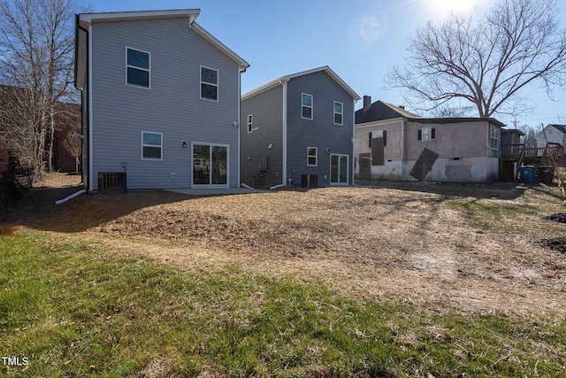 rear view of house featuring cooling unit and a yard