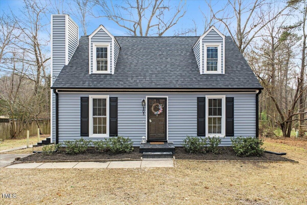 new england style home featuring a front lawn