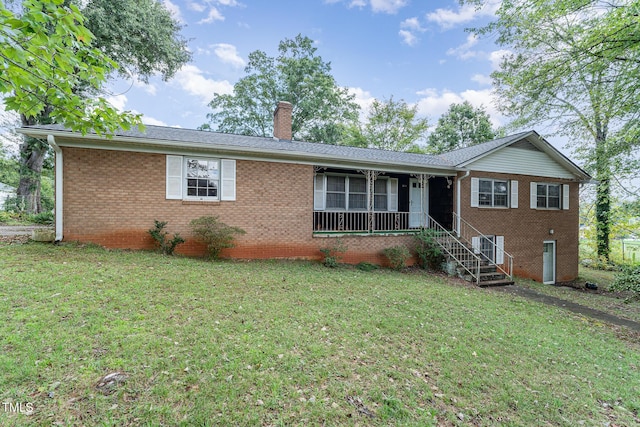 single story home featuring brick siding, a chimney, and a front lawn