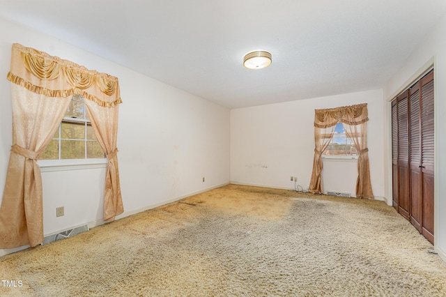 unfurnished bedroom featuring carpet, baseboards, and a closet