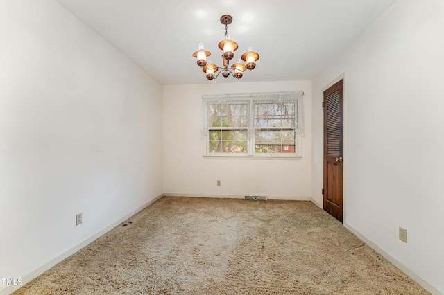 spare room with baseboards, visible vents, a chandelier, and carpet flooring