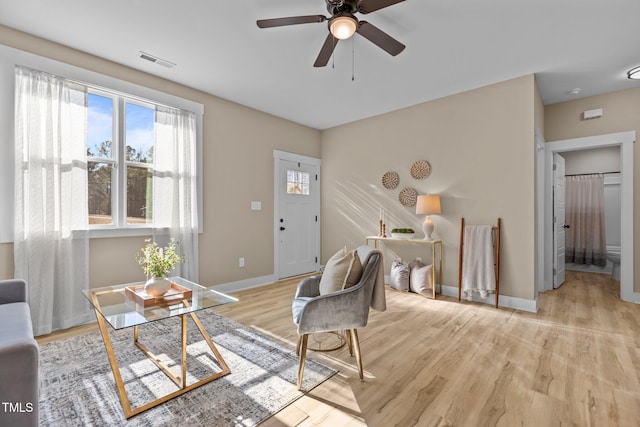 living room with light hardwood / wood-style flooring and ceiling fan