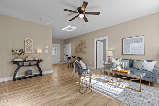 living room with ceiling fan and light hardwood / wood-style flooring