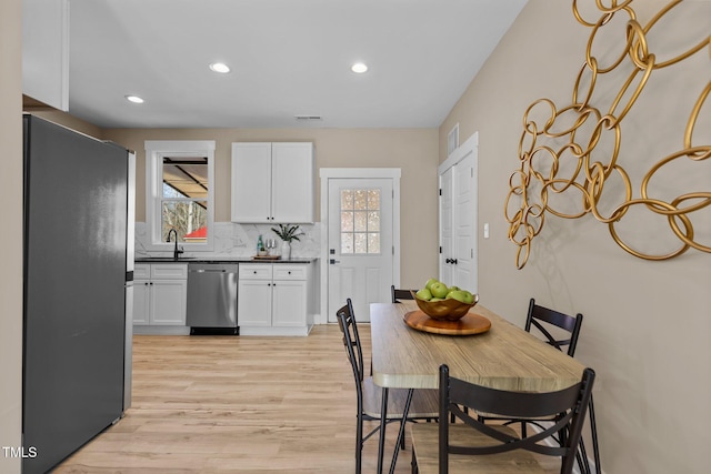 dining space with light hardwood / wood-style floors and sink