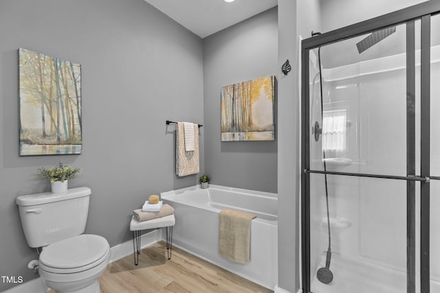 bathroom featuring wood-type flooring, shower with separate bathtub, and toilet